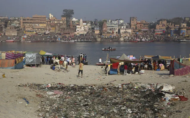 In this March 22, 2019, photo, trash is strewn on the banks of river Ganges, in Varanasi, India. Modi promised to clean up the Ganges, but gray water continues flowing not far from the banks where crowds of devotees and tourists converge for a nightly prayer. In the Indian city considered the center of the Hindu universe, Prime Minister Narendra Modi has commissioned a grand promenade connecting the sacred Ganges river with a centuries-old temple dedicated to Lord Shiva, the god of destruction. (Photo by Altaf Qadri/AP Photo)