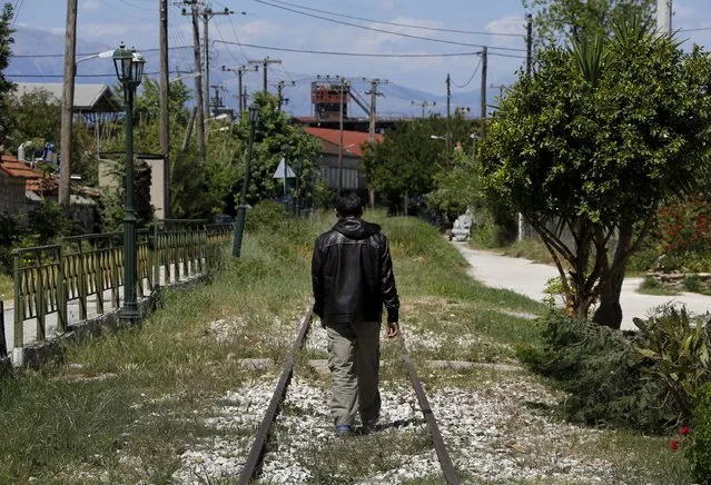 An Afghan immigrant walks on unused rail tracks by the ferry terminal in the western Greek town of Patras May 4, 2015. (Photo by Yannis Behrakis/Reuters)