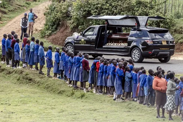 Student line up next to the road to see the hearse carrying the coffin of late marathon runner Kelvin Kiptum during his funeral proceedings in the village of Chepkorio, on February 22, 2024. Kenya's world-record holding marathon runner Kelvin Kiptum, a prodigy who ran three of the seven fastest marathons in history and was ranked first among the world's men's marathon runners, tragically died in a car crash in Kenya on February 11, 2024 at the age of 24, in an accident that shocked the world and plunged the East African nation into mourning. (Photo by Luis Tato/AFP Photo)