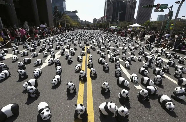 Papier mache pandas, created by French artist Paulo Grangeon, are seen displayed outside the Taipei City Hall as part of an exhibition called “Pandas on Tour”, February 28, 2014. According to local media, the event was launched by the World Wildlife Fund (WWF) first in Paris in 2008. Approximately 1,600 panda sculptures were displayed in the exhibition to remind people of the similar number of giant pandas still living in the wild and call on people's protection of endangered species. (Photo by Patrick Lin/Reuters)