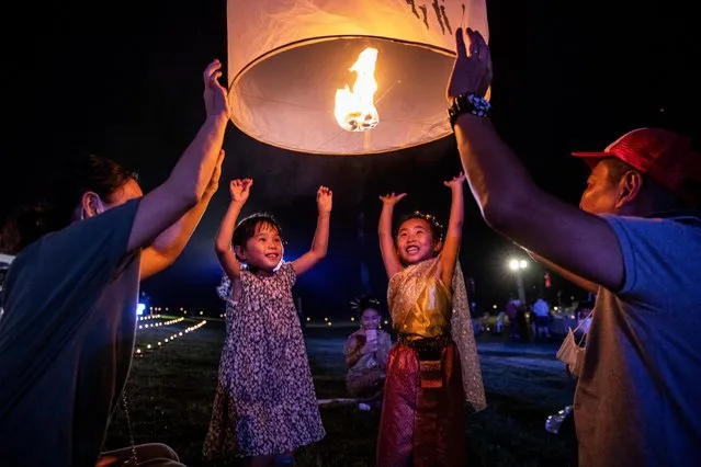 Children launch “khom loy”, lanterns, into the sky during the Yee Peng Festival on November 20, 2021 inLamphun, Thailand. The Gassan Panorama Golf Course in northern Thailand hosts its annual Yee Peng Festival, the festival of lights, where Thai's launch “khom loy”, lanterns, into the sky on the 12th Thai lunar month. Yee Peng 2021 is the first major festival held in Thailand since reopening to international tourists on November 1, 2021. (Photo by Lauren DeCicca/Getty Images)
