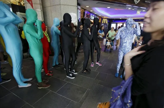 Participants wearing Zentai costumes, or skin-tight bodysuits from head to toe, take part in a march down the shopping district of Orchard Road during Zentai Art Festival in Singapore May 23, 2015. (Photo by Edgar Su/Reuters)