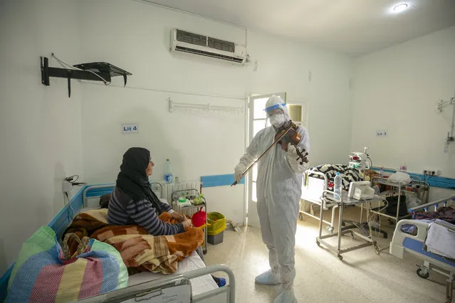 Dr. Mohamed Salah Siala, 25, plays violin for his COVID-19 patients during their treatment process for boosting the morale of coronavirus sufferers who remained isolated and needed a smile, at Hedi Chaker Hospital in Sfax, Tunisia on March 02, 2021. (Photo by Yassine Gaidi/Anadolu Agency via Getty Images)