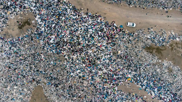 Aerial view of used clothes discarded in the Atacama desert, in Alto Hospicio, Iquique, Chile, on September 26, 2021. EcoFibra, Ecocitex and Sembra are circular economy projects that have textile waste as their raw material. The textile industry in Chile will be included in the law of Extended Responsibility of the Producer (REP), forcing clothes and textiles importers take charge of the waste they generate. (Photo by Martin Bernetti/AFP Photo)