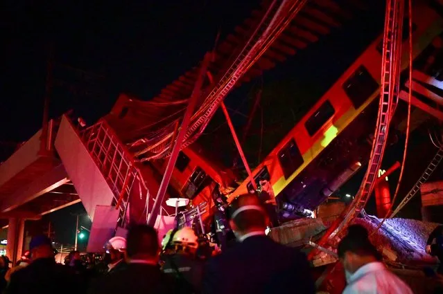 Rescue workers gather at the site of a metro train accident after an overpass for a metro partially collapsed in Mexico City on May 3, 2021. At least 13 people were killed and dozens injured in a metro train accident in the Mexican capital on May 3, the authorities said. (Photo by Pedro Pardo/AFP Photo)