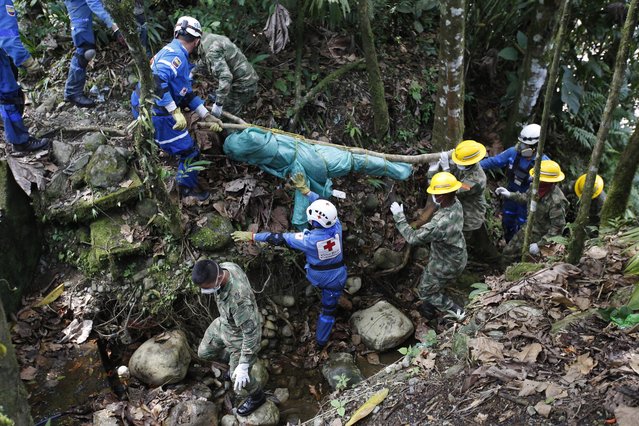 Soldiers and members of the Colombian Red Cross recover the body of a victim of a deadly avalanche that happened following heavy rains, in Mocoa, Colombia, Monday, April 3, 2017. The grim search continues for the missing in southern Colombia after surging rivers sent an avalanche of floodwaters, mud and debris through the small city, killing more than 260 people and leaving many more injured and homeless. (Photo by Fernando Vergara/AP Photo)