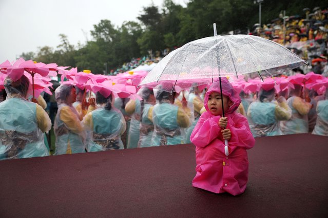 A girl holds an umbrella as buddhist believers prepare for a Lotus Lantern parade in celebration of the upcoming birthday of Buddha, in Seoul, South Korea, on May 11, 2024. (Photo by Kim Hong-Ji/Reuters)