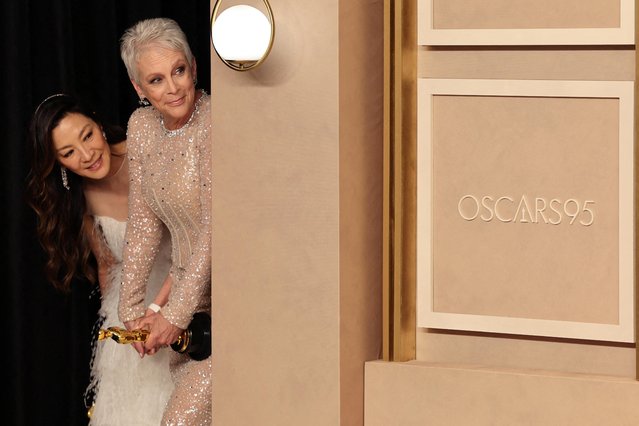 Oscar winners American actress Jamie Lee Curtis and Malaysian actress Michelle Yeoh watch backstage as Brendan Fraser (unseen) poses with his Oscar in the Oscars photo room at the 95th Academy Awards in Hollywood, Los Angeles, California, U.S., March 12, 2023. (Photo by Mike Blake/Reuters)