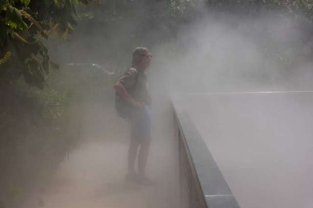 A man walks through cooling mist on a hot afternoon at a park in Brooklyn on July 08, 2024 in New York City. New Yorkers descend on area beaches, parks, pools and cooling centers as the city experiences its second heat wave of the summer season. (Photo by Spencer Platt/Getty Images)