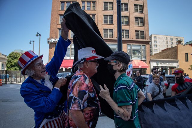 Duane Schwingel, also known as Uncle Jam, throws canvas over Pete Crotty, a Republican from Orlando, who was arguing with an activist for holding a banner in front of his MAGA merchandise along the perimeter of the Republican National Convention in Milwaukee, Wisconsin, U.S., July 18, 2024. (Photo by Adrees Latif/Reuters)