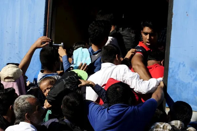 Migrants try to get onboard an overloaded train at Gevgelija train station in Macedonia, near the border with Greece, on their transit route to Europe July 19, 2015. (Photo by Ognen Teofilovski/Reuters)