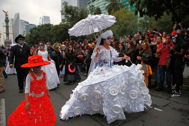 People dressed as Catrinas parade down Mexico City's iconic Reforma avenue during celebrations for the Day of the Dead in Mexico, Saturday, October 26, 2019. (Photo by Ginnette Riquelme/AP Photo)