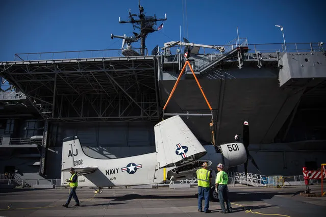 A Douglas A-1 Skyraider is moved onto the flight deck of the Intrepid Sea, Air & Space Museum by crane on May 20, 2014 in New York City. The plane served as a single-seat attack aircraft by the U.S. military from 1946 to 1985. This specific plane is named the XBT2D-1 and was transported in pieces from the Naval Air Station Oceana in Virginia and reassembled on site. (Photo by Andrew Burton/Getty Images)