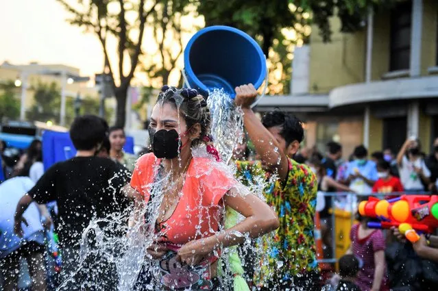 A woman wearing a protective face mask makes merit during the Songkran holiday which marks the Thai New Year during the coronavirus disease (COVID-19) outbreak, in Bangkok, Thailand, April 13, 2022. (Photo by Chalinee Thirasupa/Reuters)