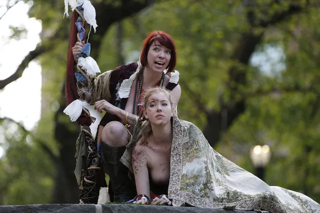 Gina Marie Russell, left, as the sorcerer “Prospero”,and Marisa Roper as “Miranda”, headline an all-female cast who at times perform fully nude during the Outdoor Co-ed Topless Pulp Fiction Appreciation Society Theater Company's production of Shakespeare's “The Tempest”, in Central Park, Thursday, May 19, 2016, in New York. This production of “Tempest” focuses on the contrast between the harsh restrictions of “civilization” and the Edenic, magic-suffused tropical island on which the sorcerer Prospero and his daughter Miranda live in exile for twelve years. The play, which will also be performed Friday afternoon, was staged at Summit Rock, Central Park's highest elevation. (Photo by Kathy Willens/AP Photo)