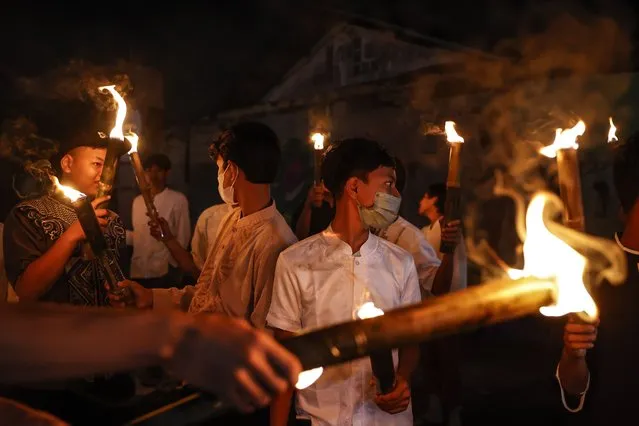Youths hold torches during a torch parade to welcome the holy month of Ramadan at a residential area in Jakarta, Indonesia, 26 March 2022. The beginning of Ramadan is expected to fall on 02 April. Muslims around the world celebrate the holy month of Ramadan by praying during the night time and abstaining from eating, drinking, and sexual acts during the period between sunrise and sunset. Ramadan is the ninth month in the Islamic calendar and it is believed that the revelation of the first verse in the Koran was during its last 10 nights. (Photo by Mast Irham/EPA/EFE)