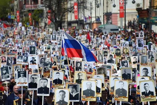 People carry portraits of their relatives - WWII soldiers - as they take part in the Immortal Regiment march in the far eastern city of Vladivostok on May 9, 2022. Russia celebrates the 77th anniversary of the victory over Nazi Germany. (Photo by Pavel Korolyov/AFP Photo)