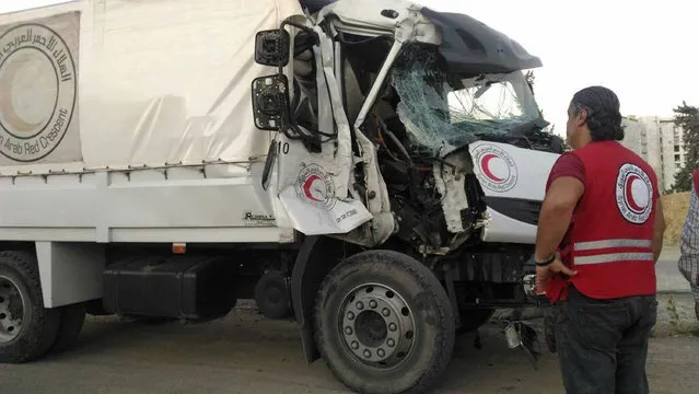 This image provided by the Syrian Arab Red Crescent shows the aftermath of an attack on a humanitarian aid convoy that came under fire shortly before dark Saturday, June 17, 2017, outside Damascus, Syria. The International Committee of the Red Cross says the humanitarian aid convoy to a besieged opposition area outside Syria’s capital has come under attack, wounding a driver and thwarting the first such mission to the area in eight months. (Photo by Syrian Arab Red Crescent via AP Photo)