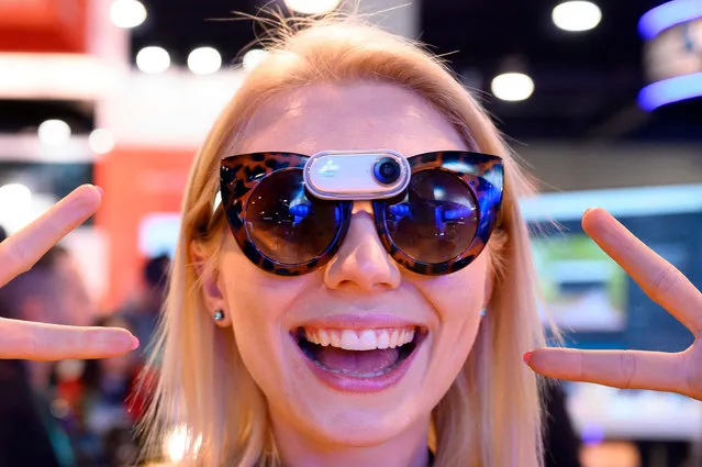 Insta360 representative Hannah Wilson models the company's Go camera, January 7, 2020 at the 2020 Consumer Electronics Show (CES) in Las Vegas, Nevada. The Insta360 Go is a tiny stabilized camera that weight less than 20 grams (less than one once), which can be worn as a pendant or on ones eyeglasses. (Photo by Robyn Beck/AFP Photo)