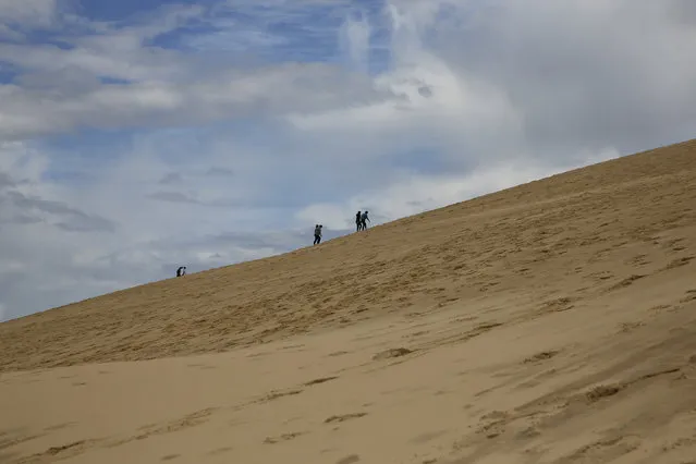 People climb Dune du Pilat (Dune of Pilat), the tallest sand dune in Europe, in La Teste de Buch, near Bordeaux, France, June 15, 2016. (Photo by Sergio Perez/Reuters)