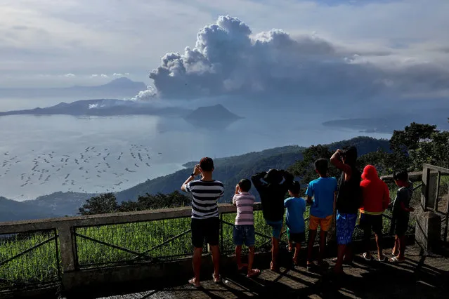 Residents look at the errupting Taal Volcano in Tagaytay City, Philippines, January 13, 2020. (Photo by Eloisa Lopez/Reuters)