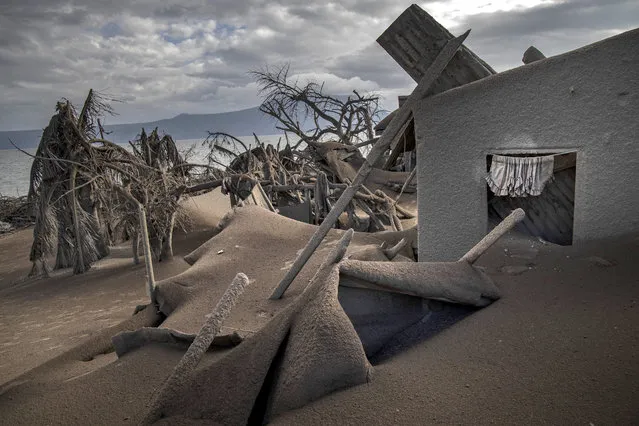 Houses near Taal Volcano's crater are seen buried in volcanic ash from the volcano's eruption on January 14, 2020 in Taal Volcano Island, Batangas province, Philippines. The Philippine Institute of Volcanology and Seismology raised the alert level to four out of five, warning that a hazardous eruption could take place anytime, as authorities have evacuated tens of thousands of people from the area. An estimated $10 million worth of crops and livestock have been damaged by the on-going eruption, according to the country's agriculture department. (Photo by Ezra Acayan/Getty Images)