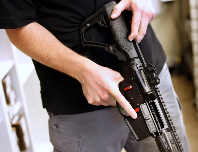 Salesman, Ryan Martinez  holds an  AR-15 at the “Ready Gunner” gun store in Provo, Utah, U.S., June 21, 2016. (Photo by George Frey/Reuters)