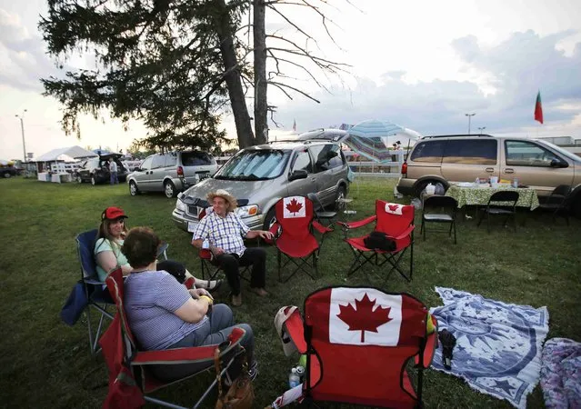 A Portuguese-Canadian family enjoys a tailgate party during the intermission at an Azorean “tourada a corda” (bullfight by rope) in Brampton, Ontario August 15, 2015. (Photo by Chris Helgren/Reuters)