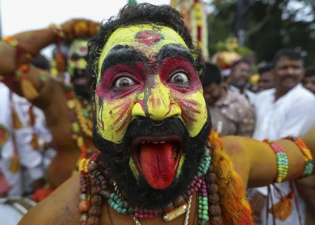 A man dressed as Pothuraju, a mythical character, performs rituals during the Bonalu festival in Hyderabad, India, Thursday, June 30, 2022. Bonalu is a month-long Hindu folk festival of the Telangana region dedicated to Kali, the Hindu goddess of destruction. (Photo by Mahesh Kumar A./AP Photo)