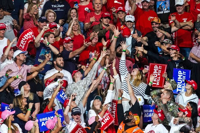 Supporters reach for a “Make America Great Again” hat tossed by a campaign staffer during a campaign rally by former US President and Republican presidential candidate Donald Trump in Macon, Georgia, on November 3, 2024. (Photo by Elijah Nouvelage/AFP Photo)