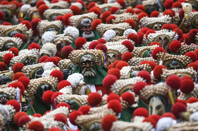 Hundreds of fools of the Elzacher Schuttig walk through the main street during the traditional Schuttig jump carnival parade in Elzach, Germany, Sunday, February 23, 2020. (Photo by Patrick Seeger/dpa via AP Photo)