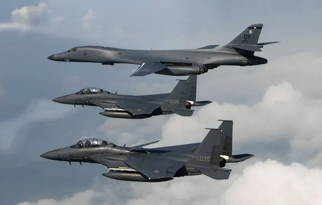 This handout photo taken and released by the US Air Force on July 30, 2017 shows a US Air Force B-1B Lancer (top) assigned to the 9th Expeditionary Bomb Squadron, deployed from Dyess Air Force Base, Texas, being joined by Republic of Korea air force F-15s, during a 10-hour mission from Andersen Air Force Base, Guam, into Japanese airspace and over the Korean Peninsula. American forces on July 30 successfully tried out a missile interception system the US hopes to set up on the Korean peninsula, military officials said following a trial just days after North Korea's second test of an ICBM. (Photo by Kamaile Casillas/AFP Photo)