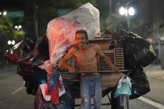 A man pulls a cart of recyclable items to sell in downtown Sao Paulo, Brazil, Monday, July 25, 2022. (Photo by Andre Penner/AP Photo)