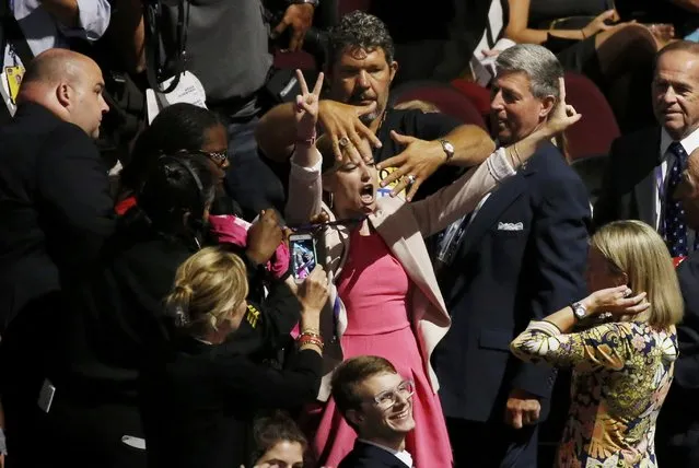People in the crowd try to block anti-war protestor Alli McCracken (C) of the “Code Pink” activist group during the opening session of the Republican National Convention in Cleveland, Ohio, U.S., July 18, 2016. (Photo by Carlo Allegri/Reuters)