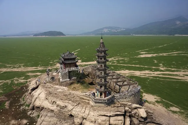 A picture taken with a drone shows Luoxingdun stone island in Poyang Lake, Jiangxi Province, China, 24 August 2022. Severe drought exposed ancient Luoxingdun stone island in the middle of dried Poyang Lake in East China. It's the first time in 71 years that the historic island can be fully seen. East China Jiangxi Province has been experiencing severe drought since July 15. About 655,000 people have been mobilized to participate in the drought relief campaign in the province that is suffering economic losses of 147 million euros. China's long-running and severe heatwave caused a record-breaking drought across the country, causing some rivers to dry up, including parts of the Yangtze river. Lately, Sichuan province rationed public electricity usage or suspended the power supply to thousands of factories due to the power shortage. (Photo by Alex Plavevski/EPA/EFE/Rex Features/Shutterstock)