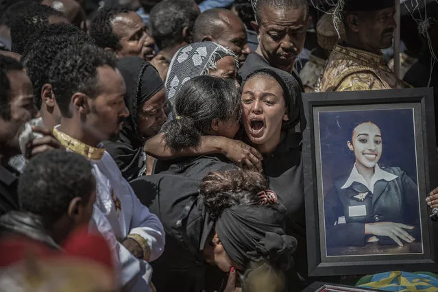 This image released by World Press Photo, Thursday April 16, 2020, by Mulugeta Ayene, The Associated Press, part of a series which won first prize in the Spot News Stories category and was also nominated for the World Press Photo Story of the Year, Relatives of a victim of the Ethiopian Airlines Flight ET302 crash mourn at a ceremony for those killed, at the Holy Trinity Cathedral in Addis Ababa, Ethiopia, on 17 March 2019, a week after the incident. (Photo by Mulugeta Ayene, The Associated Press, World Press Photo via AP Photo)