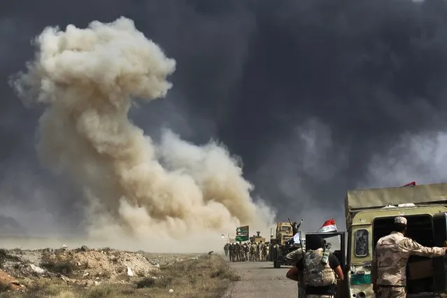 Smoke billow as Iraqi forces advance towards the Islamic State (IS) group's stronghold of Hawija on September 30, 2017 to recapture the town from the jihadists. Iraqi forces on September 29 launched an assault on the northern town of Hawija, one of the last bastions in the country still held by the Islamic State group, which is also under attack in neighbouring Syria. (Photo by Ahmad Al-Rubaye/AFP Photo)