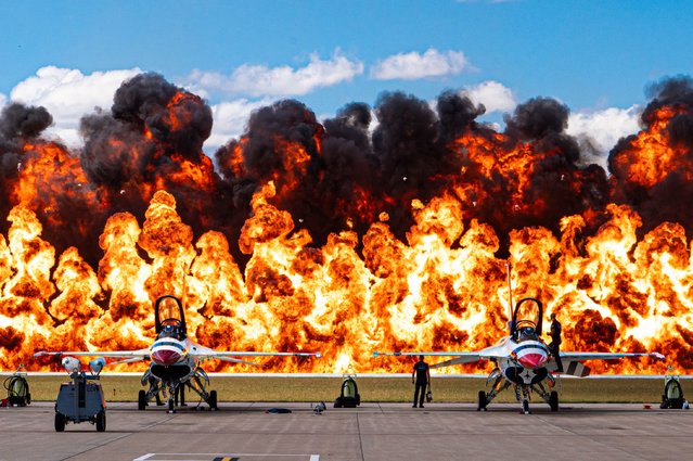 A “double wall of fire” pyrotechnic display, is triggered behind F-16 Fighting Falcon fighter jets, assigned to the Air Force Thunderbirds during the Speed of Sound Airshow, at Rosecrans Air National Guard Base in St. Joseph, Missouri, September 15, 2024. The explosion was part of the “Tora, Tora, Tora” Commemorative Air Force's performance. The air show was hosted by the 139th Airlift Wing, and city of St. Joseph to thank the community for their support. The air show committee estimated around 50,000 people attended during the weekend performances in which the Thunderbirds were featured. (Photo by Master Sgt. Patrick Evenson/U.S. Air National Guard)