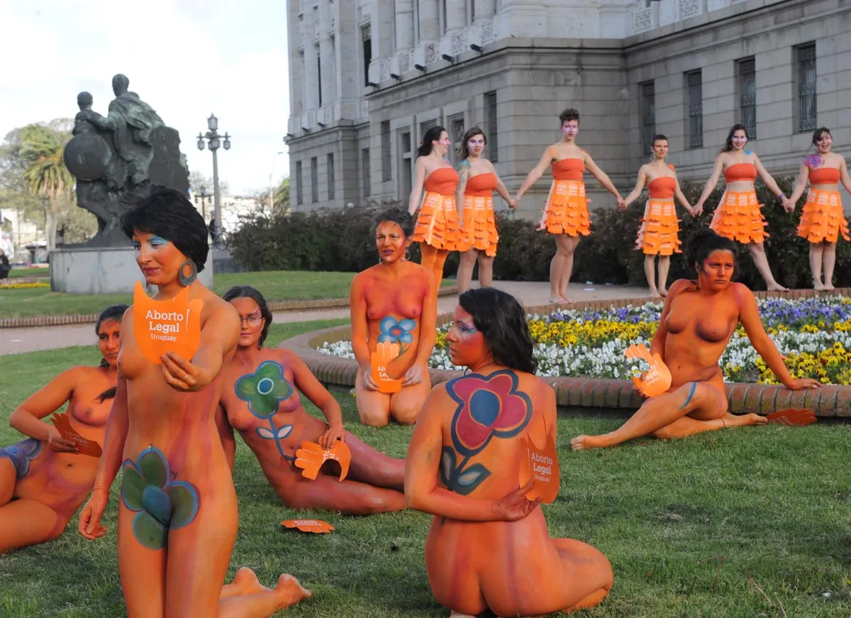 Women with body paintings and signs reading "Legal abortion", tak...