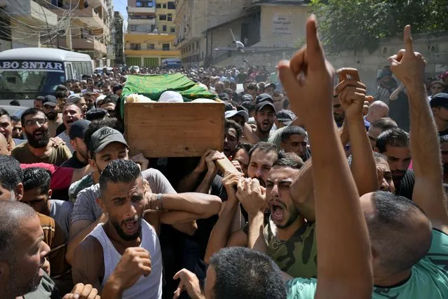 Mourners chant slogans as they carry the coffin of Palestinian Abdul-Al Omar Abdul-Al, 24, who was on a boat carrying migrants from Lebanon that sank in Syrian waters, during his funeral processions, in the Palestinian refugee camp of Nahr el-Bared near the northern city of Tripoli, Lebanon, Saturday, September 24, 2022. (Photo by Bilal Hussein/AP Photo)