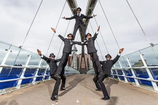The theatre and circus group “The Black Blues Brothers” perform an acrobatic routine on the Millennium Bridge at Salford Quays during a photocall to promote their upcoming three-night run at “The Lowry” in Salford, Britain, 04 October 2022. The performers, from the Kenyan social circus trust Sarakasi, use acrobatics, circus skills and dance to pay tribute to the 1980 musical comedy “The Blues Brothers”. (Photo by Adam Vaughan/EPA/EFE)
