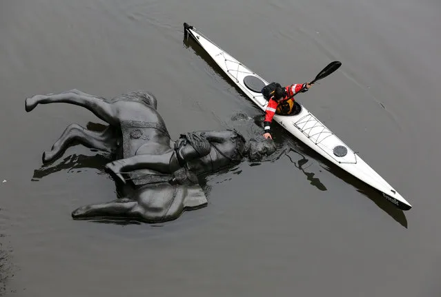A replica equestrian statue of King Edward VII is nudged into position by Jon McCurley of art duo Life Of A Craphead, allowing it to float down the Don River during a performance in Toronto, Ontario, Canada October 29, 2017. (Photo by Chris Helgren/Reuters)