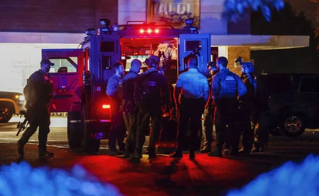 Law enforcement officers congregate outside an armored vehicle at the Aldi on New Bern Avenue in Raleigh after five people were shot and killed in the Hedingham Neighborhood and Nuese River Trail area in Raleigh, N.C., Thursday, October 13, 2022. (Photo by Travis Long/The News & Observer via AP Photo)