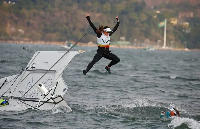 Alexandra Maloney and Molly Meech of New Zealand jump off their boat after winning the silver medal in the women's 49er FX class medal race, August 18, 2016. (Photo by Nic Bothma/EPA)