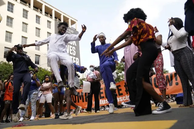 People dance on the Black Lives Matter Plaza during a demonstration against racial inequality in the aftermath of the death in Minneapolis police custody of George Floyd, in Washington, June 14, 2020. Washington Mayor Muriel Bowser, who has sparred with President Donald Trump over his sometimes heavy-handed response to the rallies and marches in the nation's capital, had the slogan “Black Lives Matter” painted in massive yellow letters on the newly named “Black Lives Matter Plaza” on 16th Street leading to the White House. (Photo by Erin Scott/Reuters)