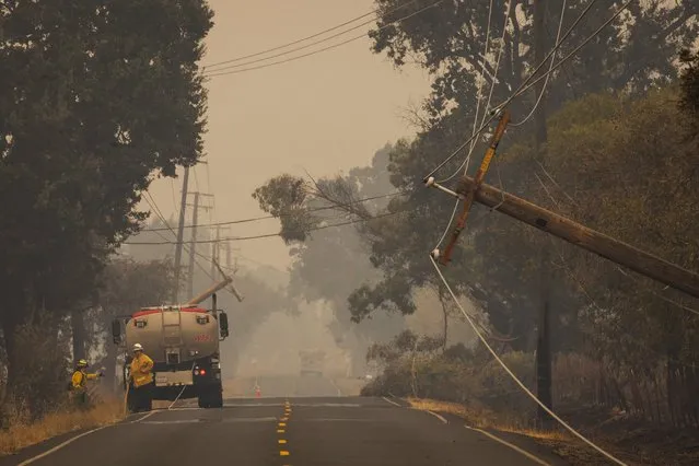 Damaged power lines hang over Butts Canyon Road as crews work during the so-called Valley Fire near Middleton, California September 14, 2015. (Photo by David Ryder/Reuters)