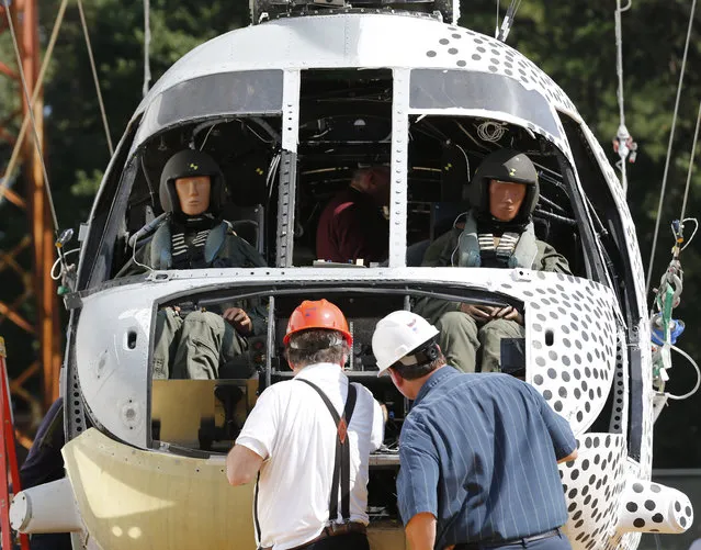 NASA engineers check sensors as they prepare to crash a former military helicopter that's been retrofitted with a variety of composite subfloors to see if the material can reduce the likelihood of injuries for occupants at the NASA Langley Research Center in Hampton, Va., Wednesday, October 1, 2014. The full-scale crash tests a former Marine helicopter airframe that is swung from a large pendulum at a slight angle and slam into a pile of soil at 30 miles per hour. (Photo by Steve Helber/AP Photo)