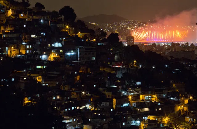With the Morro dos Prazeres slum in the foreground, fireworks explode over the Maracana stadium during the closing ceremony of the 2016 Summer Olympic Games in Rio de Janeiro, Brazil, Sunday August 21, 2016. (Photo by Leo Correa/AP Photo)