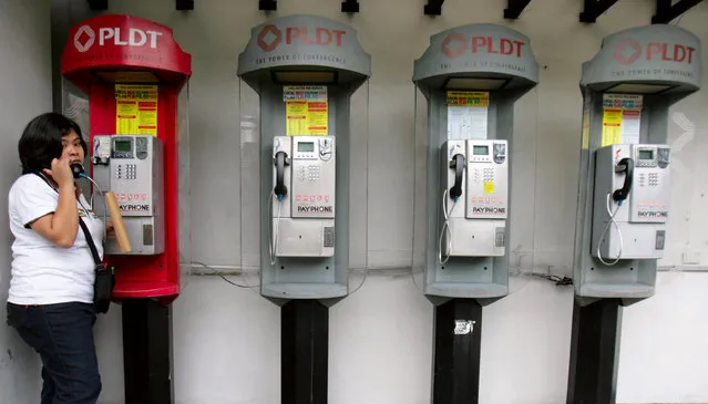 A woman uses a pay phone outside a Philippine Long Distance Telephone Company (PLDT) office in Manila November 3, 2009. (Photo by Cheryl Ravelo/Reuters)