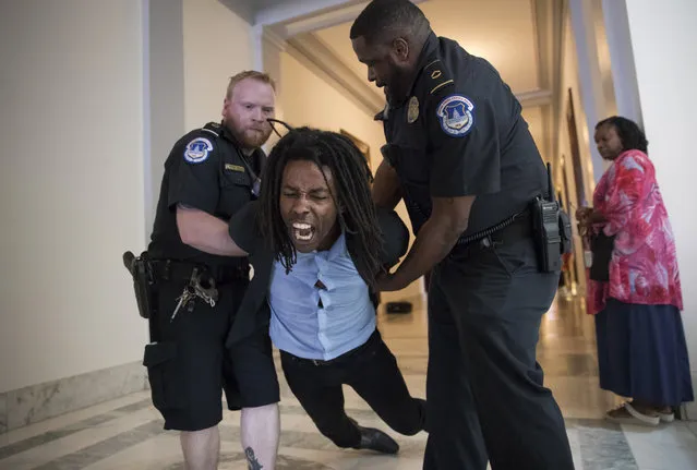 A demonstrator is taken into custody by U.S. Capitol Police during a protest against the Republican health care bill outside the offices of Sen. Jeff Flake, R-Ariz., and Sen. Ted Cruz, R-Texas, on Capitol Hill in Washington on July 10, 2017. (Photo by J. Scott Applewhite/AP Photo)